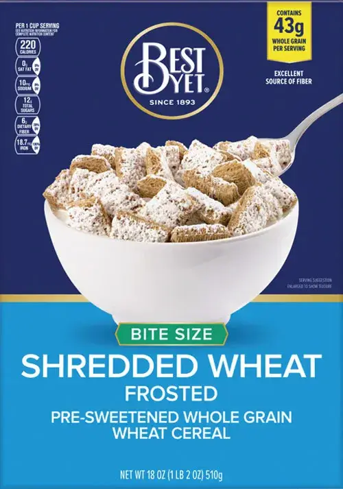 Bowl of frosted shredded wheat cereal with spoon.