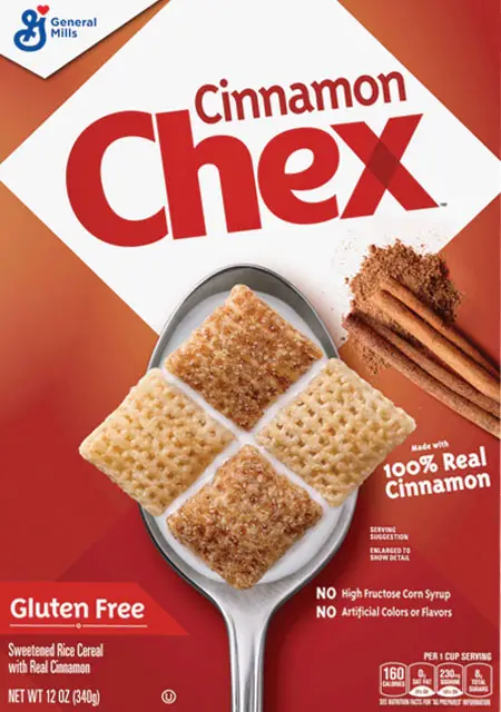 Cinnamon Chex cereal on spoon with cinnamon sticks.