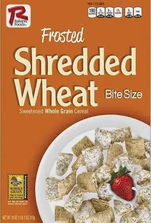 Cereal bowl with frosted shredded wheat and strawberry.